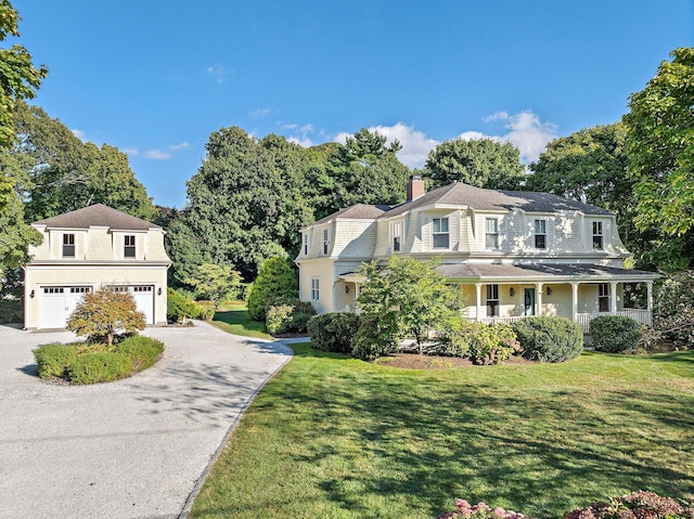 view of front of property featuring a garage, a front lawn, and a porch