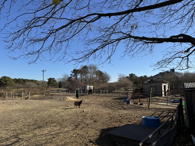 view of yard featuring a rural view and an outbuilding