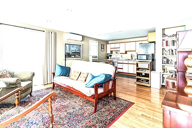 living room featuring light wood-style floors and a wall mounted AC