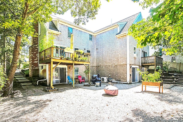 rear view of house with a patio area, an outdoor fire pit, and a wooden deck