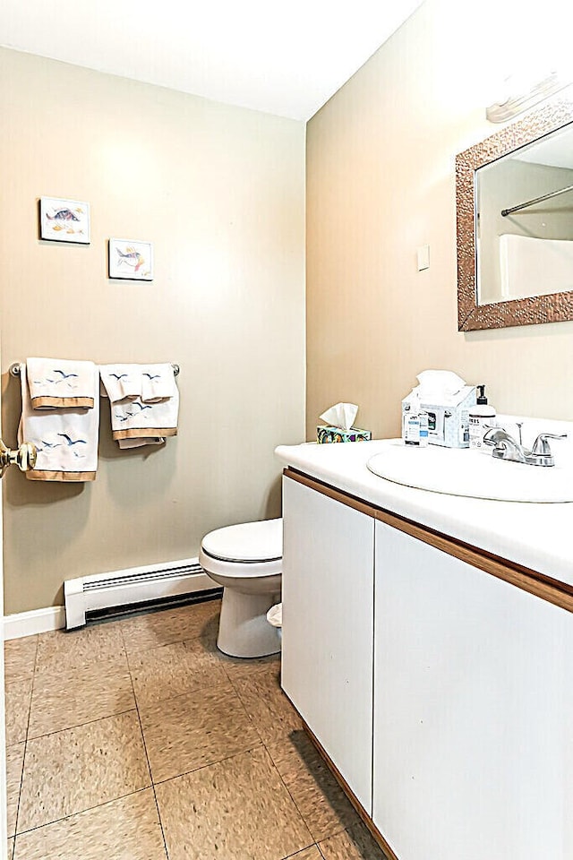 bathroom with a baseboard heating unit, vanity, and toilet