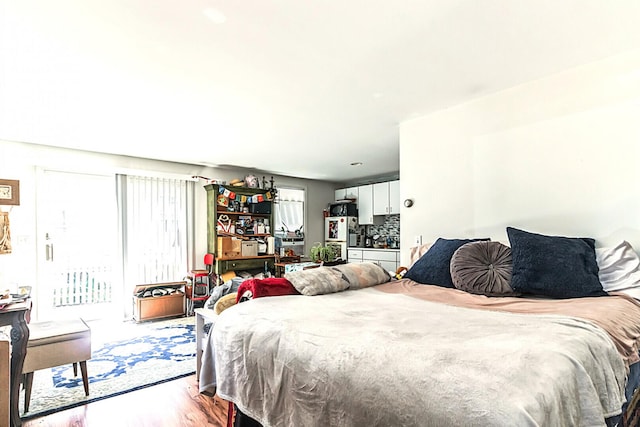 bedroom featuring light wood finished floors and access to outside