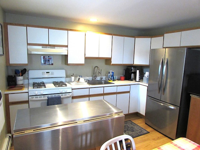 kitchen with freestanding refrigerator, gas range gas stove, under cabinet range hood, white cabinetry, and a sink