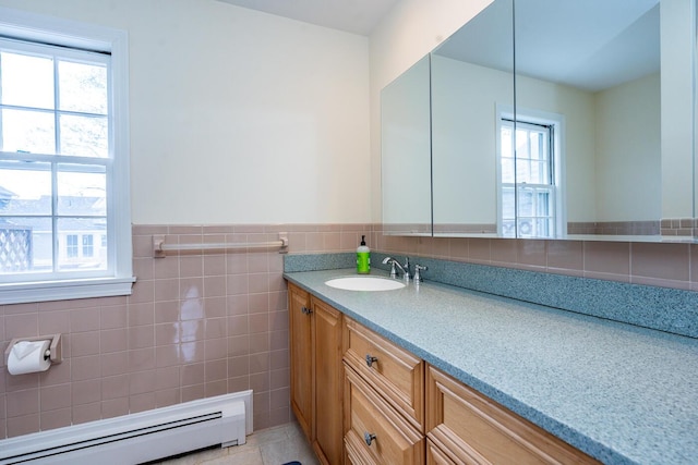 bathroom with a baseboard heating unit, vanity, tile walls, and a wainscoted wall