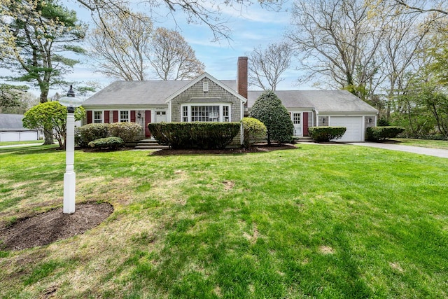 ranch-style home with concrete driveway, a chimney, an attached garage, and a front yard