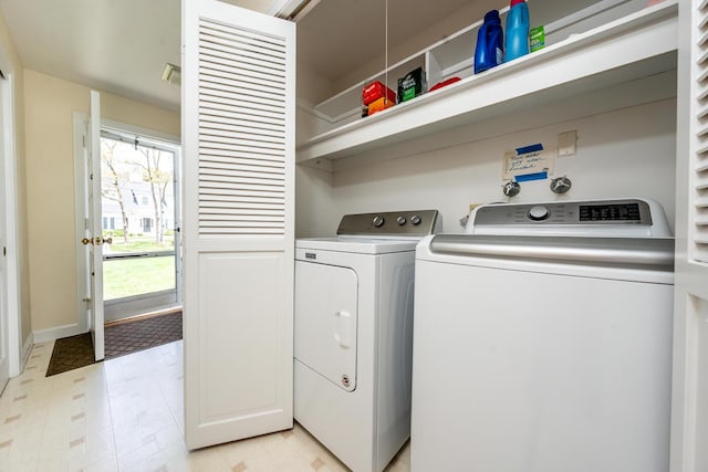 laundry area with washing machine and clothes dryer, baseboards, and light flooring