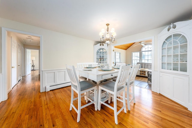 dining space featuring a baseboard heating unit, a chandelier, light wood finished floors, and ceiling fan