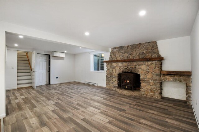 unfurnished living room featuring hardwood / wood-style floors, a baseboard radiator, and a wall mounted air conditioner