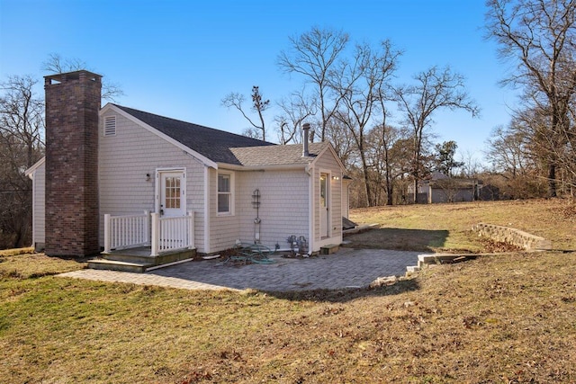 rear view of property with a yard and a patio area