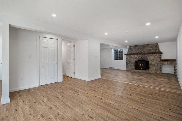 unfurnished living room featuring light hardwood / wood-style flooring and a baseboard heating unit