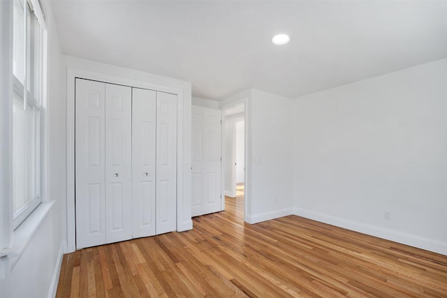 unfurnished bedroom featuring a closet and light wood-type flooring