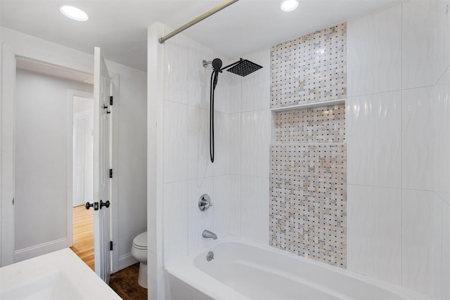 bathroom featuring hardwood / wood-style flooring,  shower combination, and toilet