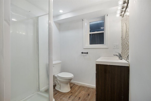 bathroom with vanity, hardwood / wood-style floors, an enclosed shower, and toilet