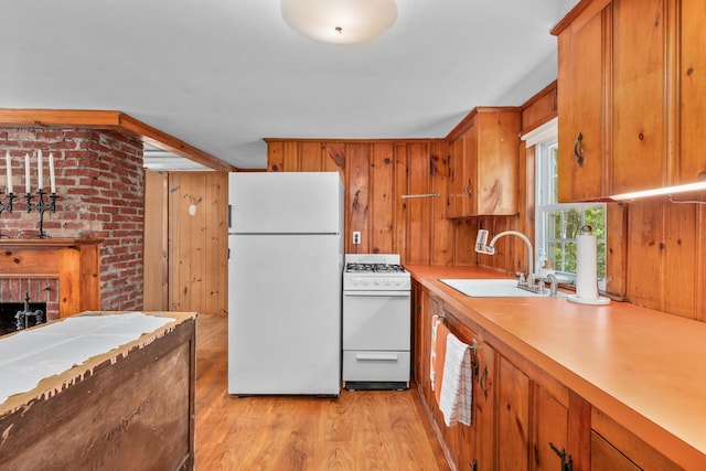 75 Swan Lake Rd, West Yarmouth, MA 02673 - kitchen featuring white appliances, a sink, brown cabinetry, light wood finished floors, and light countertops