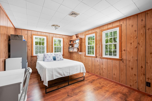 75 Swan Lake Rd, West Yarmouth, MA 02673 - bedroom with multiple windows, wood walls, wood finished floors, and baseboards