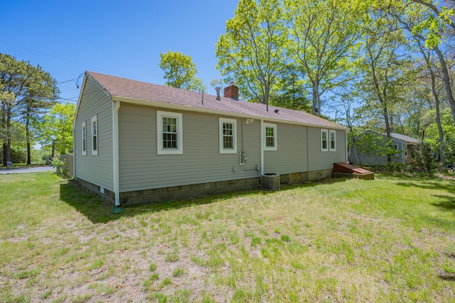75 Swan Lake Rd, West Yarmouth, MA 02673 - back of house featuring a chimney, a yard, and central AC unit