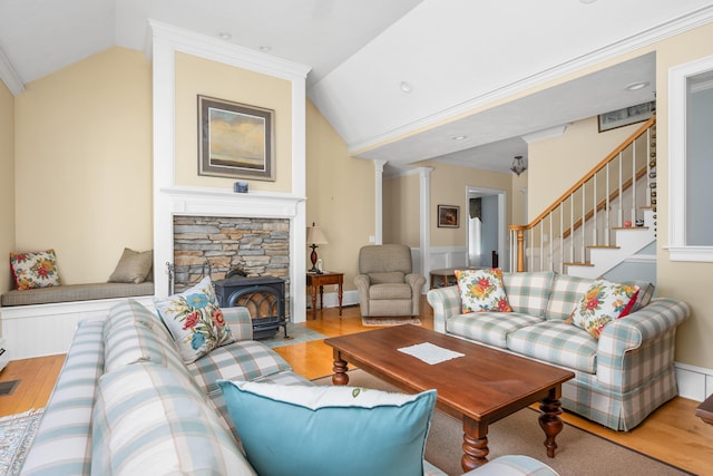 living room featuring hardwood / wood-style floors, ornamental molding, ornate columns, and vaulted ceiling