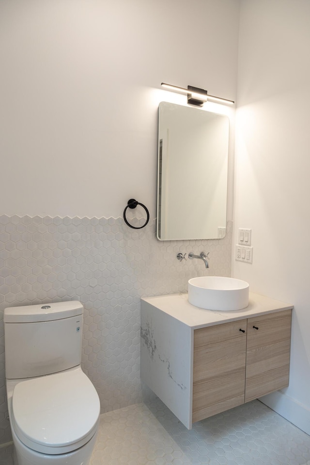 bathroom with tile walls, toilet, tile patterned flooring, and vanity