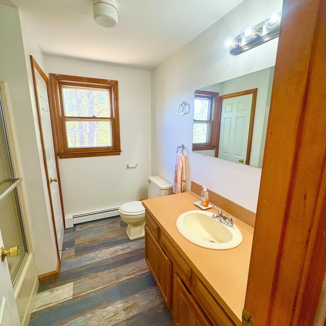 29 Lumberjack Trl, West Yarmouth, MA 02673 - full bath with a baseboard radiator, toilet, vanity, wood finished floors, and bath / shower combo with glass door