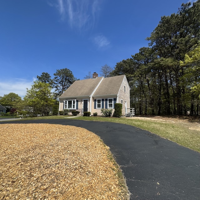 29 Lumberjack Trl, West Yarmouth, MA 02673 - view of front facade featuring a chimney, driveway, and roof with shingles