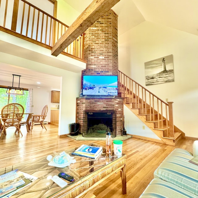29 Lumberjack Trl, West Yarmouth, MA 02673 - living area with high vaulted ceiling, a brick fireplace, wood finished floors, stairs, and baseboards