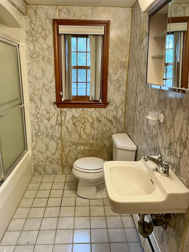 full bathroom featuring sink, toilet, combined bath / shower with glass door, and tile patterned flooring