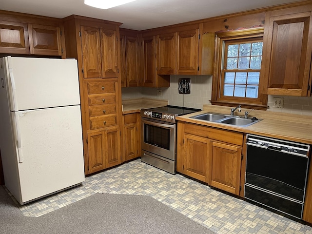 kitchen featuring stainless steel electric range oven, tasteful backsplash, dishwasher, sink, and white refrigerator