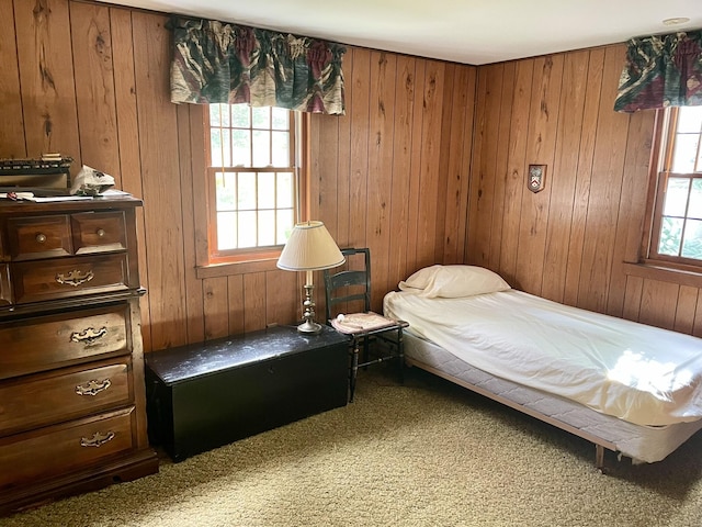 bedroom featuring carpet and wood walls