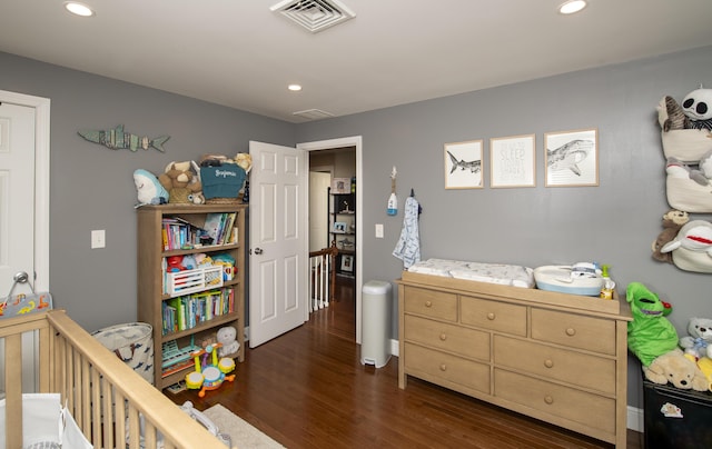 bedroom with recessed lighting, visible vents, dark wood finished floors, and a crib