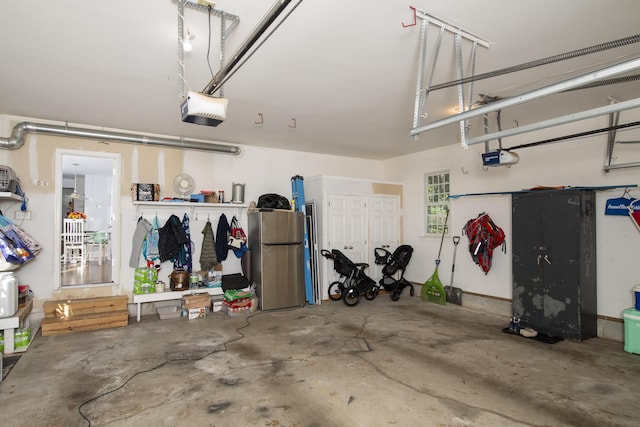 garage featuring a garage door opener and freestanding refrigerator