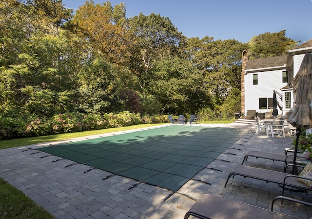 view of pool with a covered pool and a patio