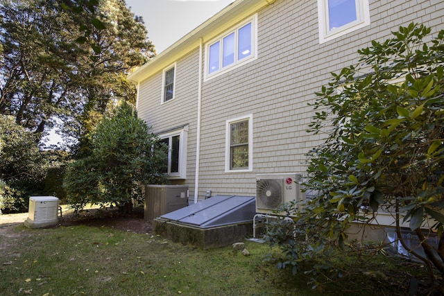 view of home's exterior featuring central air condition unit, ac unit, and a lawn