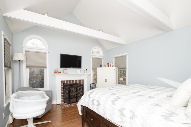 bedroom featuring lofted ceiling, a fireplace, and wood finished floors