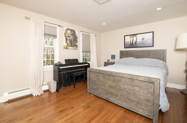 bedroom featuring a baseboard radiator, baseboards, wood finished floors, and recessed lighting