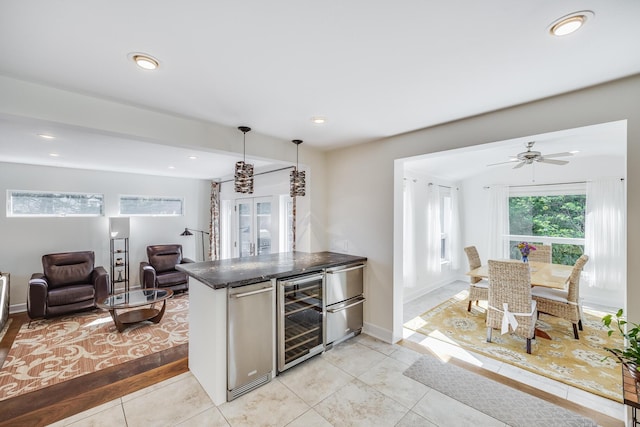 10 Westerly Dr, Bourne, MA 02532 - kitchen with beverage cooler, open floor plan, dark countertops, light tile patterned floors, and hanging light fixtures
