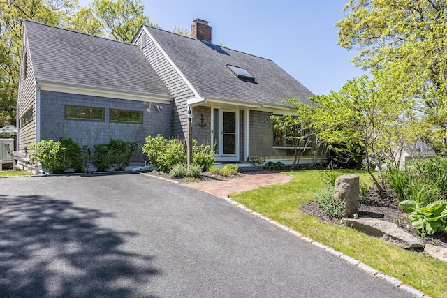 10 Westerly Dr, Bourne, MA 02532 - view of front of property with a shingled roof, a chimney, and a front yard