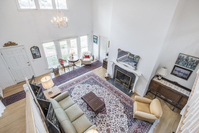 104 Seapine Rd, North Chatham, MA 02650 - living room featuring a high ceiling, a chandelier, a premium fireplace, wood finished floors, and baseboards