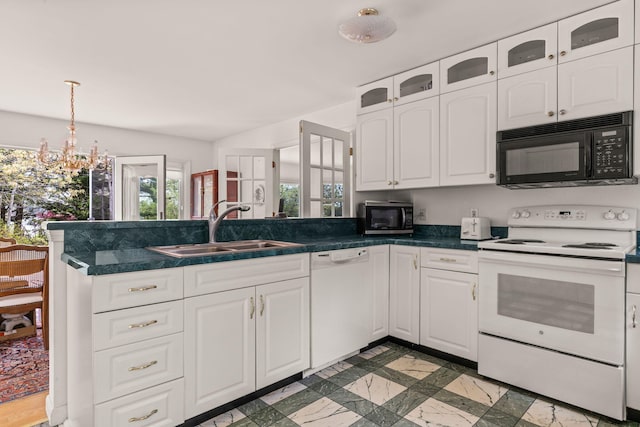 104 Seapine Rd, North Chatham, MA 02650 - kitchen with white appliances, a sink, a peninsula, dark countertops, and white cabinetry