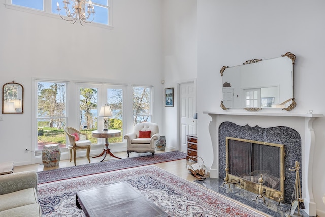 104 Seapine Rd, North Chatham, MA 02650 - living room with a high ceiling, a chandelier, a premium fireplace, and wood finished floors