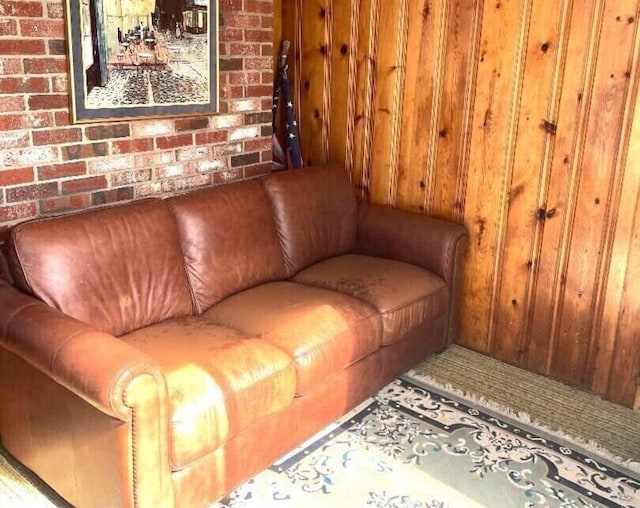 living room featuring brick wall and wood walls