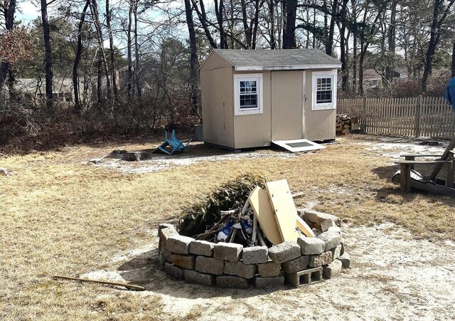 view of shed featuring a fire pit and fence