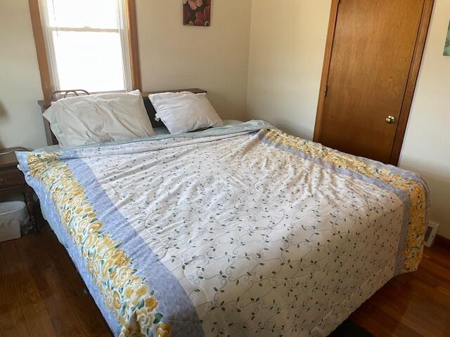 bedroom featuring a closet, visible vents, and wood finished floors