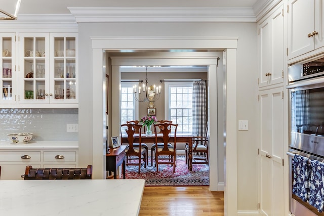 49 Atkins Rd, East Sandwich, MA 02537 - dining room with light wood-type flooring, ornamental molding, baseboards, and a notable chandelier