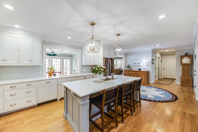 49 Atkins Rd, East Sandwich, MA 02537 - kitchen with freestanding refrigerator, a sink, light countertops, a kitchen island, and a kitchen bar