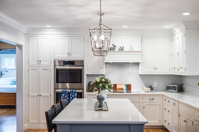 49 Atkins Rd, East Sandwich, MA 02537 - kitchen featuring stainless steel double oven, white cabinets, a notable chandelier, and pendant lighting