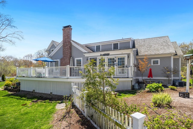 49 Atkins Rd, East Sandwich, MA 02537 - back of house with fence, a deck, a chimney, central air condition unit, and a lawn