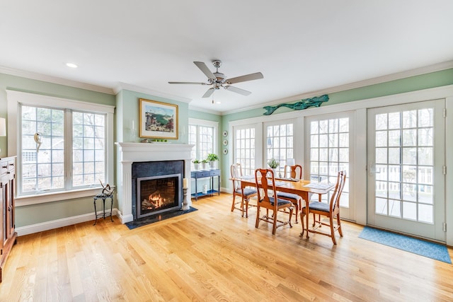 49 Atkins Rd, East Sandwich, MA 02537 - dining space featuring crown molding, a ceiling fan, light wood-style floors, baseboards, and a fireplace with flush hearth