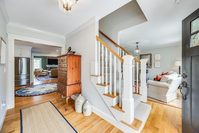 49 Atkins Rd, East Sandwich, MA 02537 - stairway with crown molding, baseboards, wood finished floors, and a fireplace
