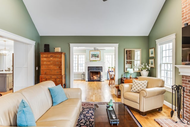 49 Atkins Rd, East Sandwich, MA 02537 - living area with a lit fireplace, light wood finished floors, and lofted ceiling