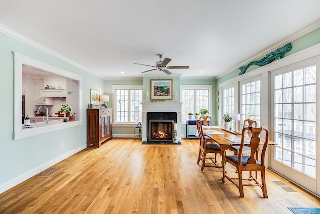 49 Atkins Rd, East Sandwich, MA 02537 - dining area with baseboards, ornamental molding, a fireplace with flush hearth, and light wood finished floors